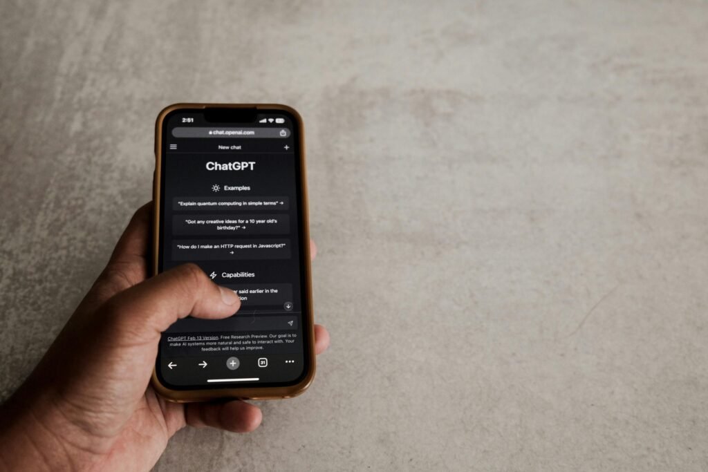 Close-up of a hand interacting with ChatGPT on a smartphone, showcasing modern AI technology.